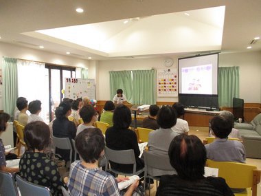 認知症カフェオープンイベント時の寸劇を地域の方々に見ていただいている写真